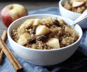 Creamy cinnamon apple quinoa breakfast bowl topped with sliced fresh apples and a sprinkle of cinnamon, perfect for a healthy morning start.