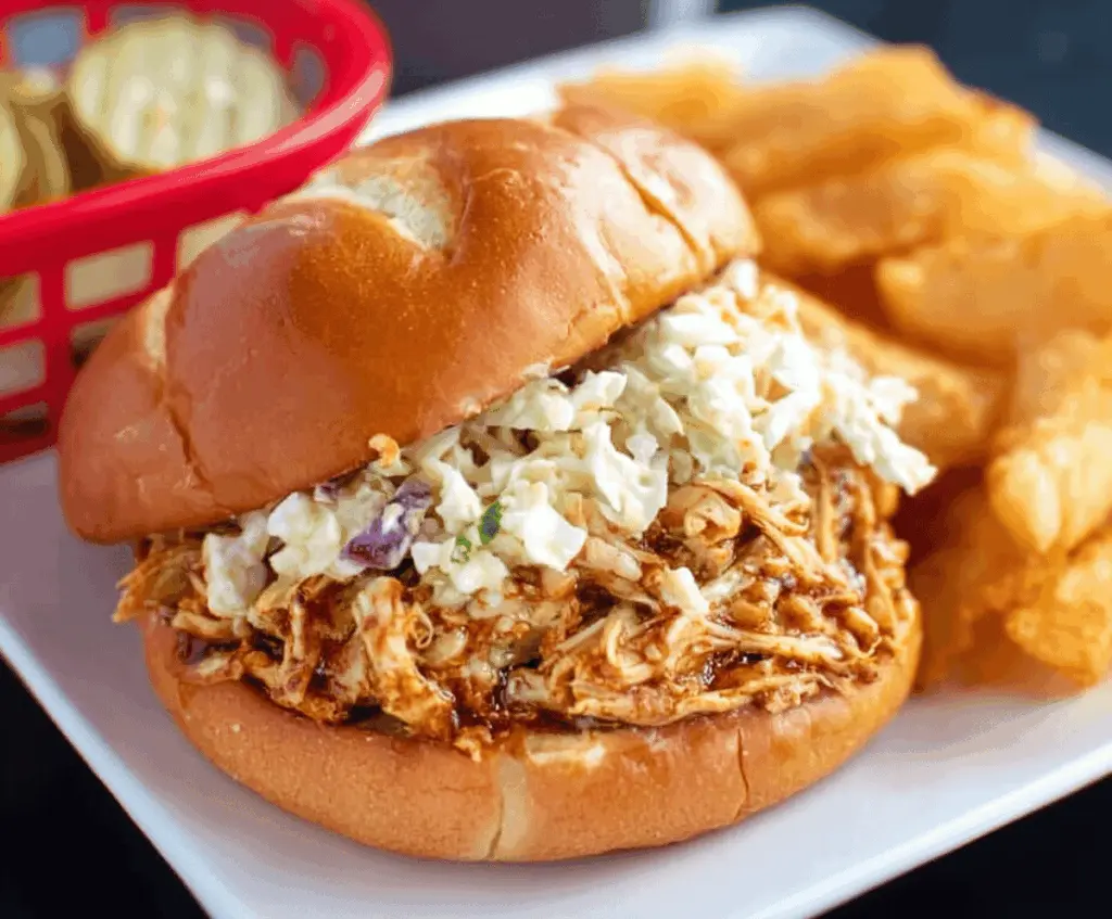 Delicious Ohio shredded chicken sandwich with crispy lettuce and tangy sauce on a toasted bun.