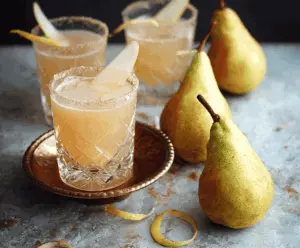 Refreshing quick spiced vanilla pear cocktail in a clear glass, garnished with a pear slice and cinnamon stick.