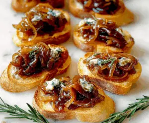 Golden caramelized onion crostini topped with melted cheese on crispy baguette slices.