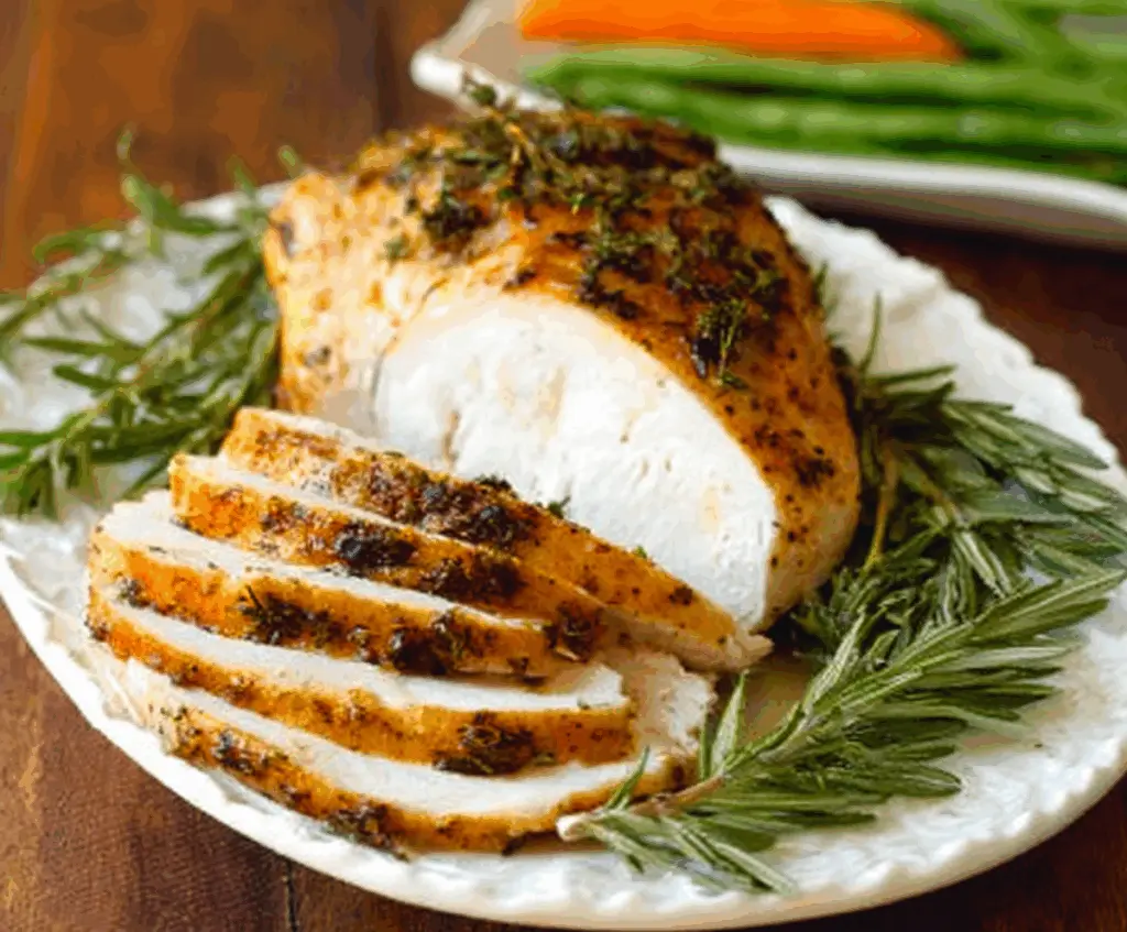 Juicy Herb-Roasted Turkey Breast garnished with fresh herbs for a perfect Christmas dinner centerpiece.