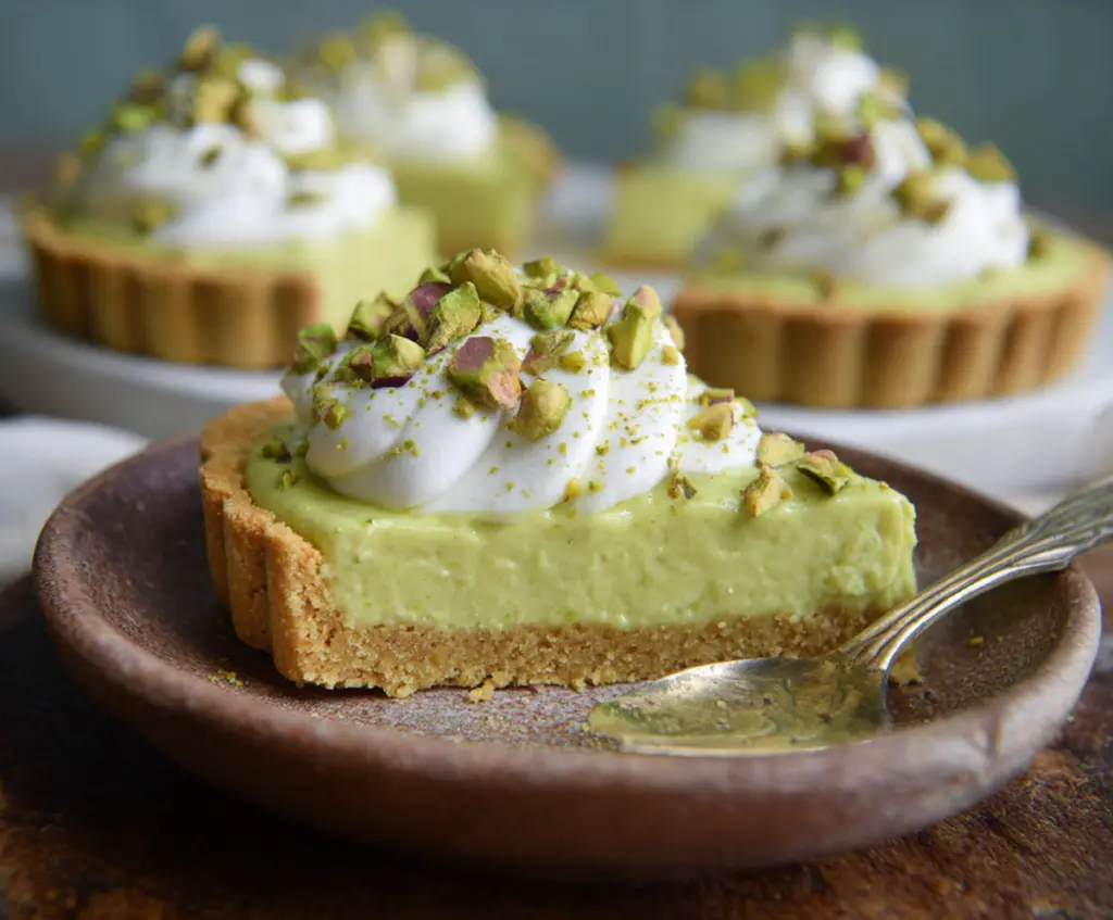 Delicious Pistachio Pudding Tart with a buttery crust and whipped cream topping.