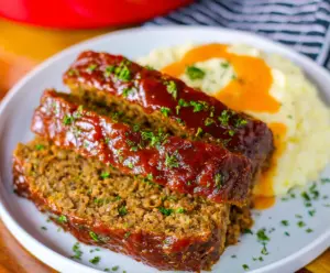 Delicious Crockpot Dr. Pepper Meatloaf served on a plate with fresh vegetables