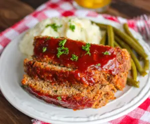 Delicious Crockpot Sloppy Joe Meatloaf served on a plate with fresh sides.