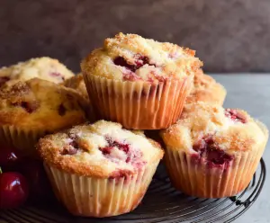 Fresh cherry muffins topped with a glaze, perfect for a quick breakfast or snack.